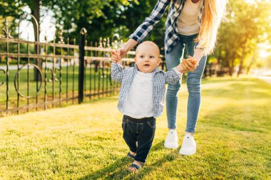 Anne, çocuğunun ilk adımını öğrenmesine yardım eder.