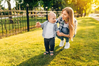 Anne, çocuğunun ilk adımını öğrenmesine yardım eder.