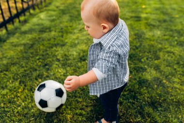 Atletik çocuk. Parkta futbol oynayan mutlu küçük çocuk. Çocuklar futbol oynuyor. Aile eğlencesi..