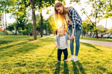 Anne, çocuğunun ilk adımını öğrenmesine yardım eder.