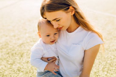 Mutlu anne portresi dışarıda çocuğunu kucaklıyor, Anneler Günü.
