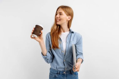 Bilgisayarlı güzel bir iş kadını izole edilmiş beyaz arka planda kahve içiyor.