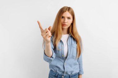 Kameraya bakan ciddi genç kadın uyarı işareti yapıyor. Katı kız parmak ile tehdit ediyor. İzole edilmiş beyaz arka planda uyarı ya da uyarı veriyor.