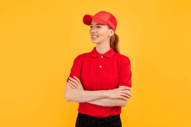 Kırmızı şapkalı mutlu kurye kadın görüntüsü izole edilmiş sarı arka planda duruyor.