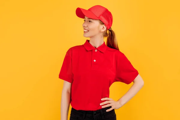 Lächelnde Junge Kurierin Roter Uniform Posiert Auf Gelbem Studiohintergrund Lieferkonzept — Stockfoto