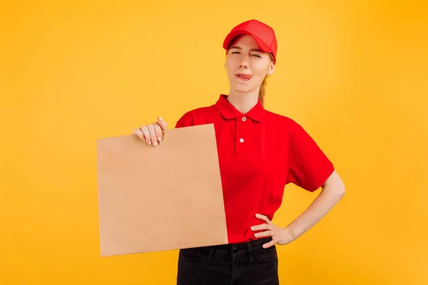 送货服务人员 头戴红帽子 身穿T恤 手持装有食物的纸袋 背景为孤立的黄色 — 图库照片