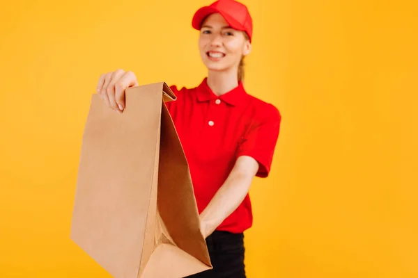 Lieferant Roter Uniform Hält Papiertüte Mit Lebensmitteln Der Hand Mitarbeiterin — Stockfoto