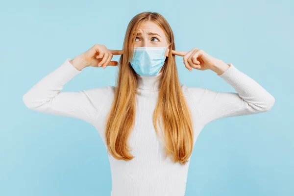 Chockad Förvånad Ung Kvinna Medicinsk Mask Täcker Öronen Med Händerna — Stockfoto