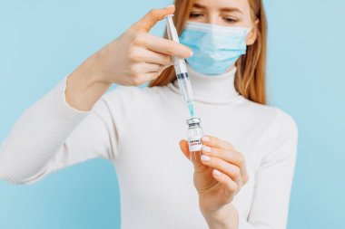 Elinde bir şişe covid-19 Coronavirus aşısı tutan genç bir kadın. Laboratuvarda analiz için biyolojik test tüpü olan bir doktor.