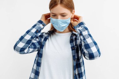 Tıbbi maskeli güzel bir kadının portresi, izole edilmiş beyaz arka planda genç bir hasta.