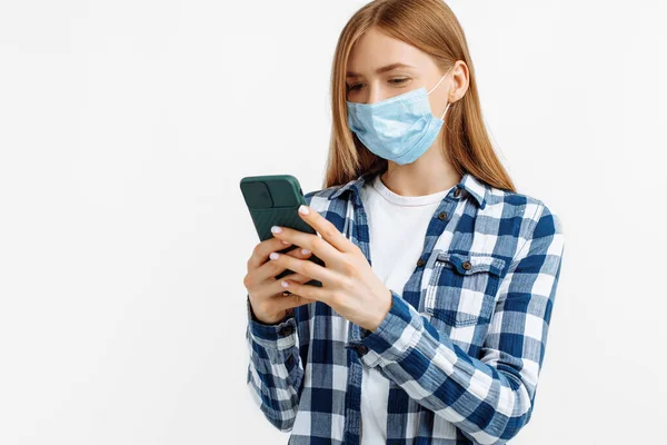 Fiatal Orvosi Maszkban Mobiltelefont Használ Izolált Fehér Háttérrel Coronavirus Pandémia — Stock Fotó