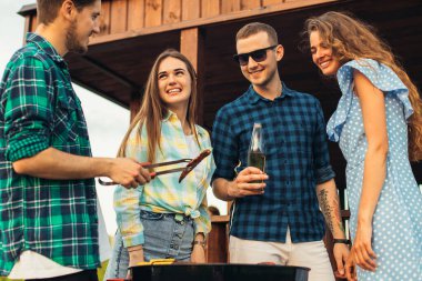 Bir grup mutlu genç arkadaş yaz kıyafetleri içinde, arkadaşlar eğleniyor, içki içiyor, yaz güneşli bir günde, yaz partisinde