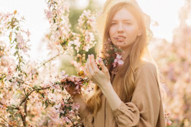 Bahar bahçesindeki güzel sarışın, çekici bir kadının portresi çiçek açan bahçedeki bir kadının.