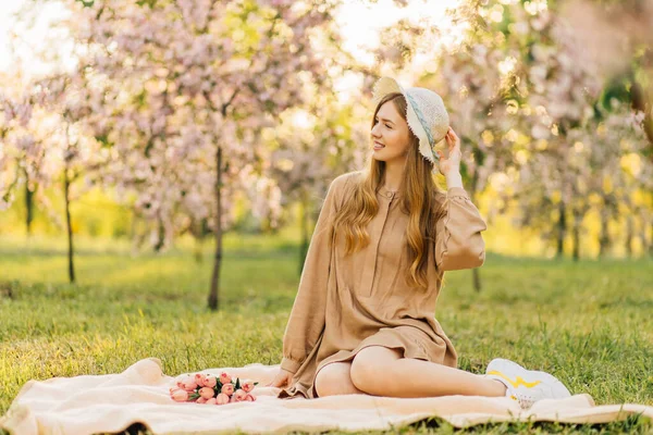 모자와 드레스를 공원의 잔디밭의 봄철의 기분을 즐기는 — 스톡 사진