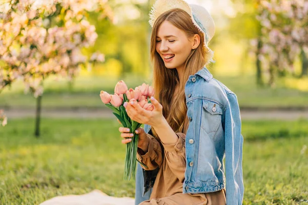 Bir bahar çiçeği buketiyle, bir bahar günü kiraz çiçeği bahçesinde, bir ağaçtan düşen çiçek yaprakları, bahar konsepti.