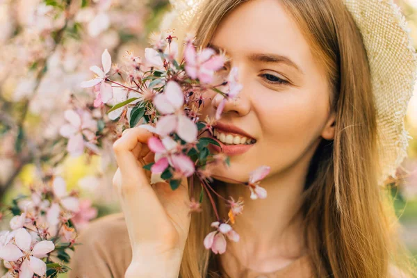 温柔微笑的年轻女子在美丽的春花园中嗅到开花枝条的芬芳 放松的概念 — 图库照片