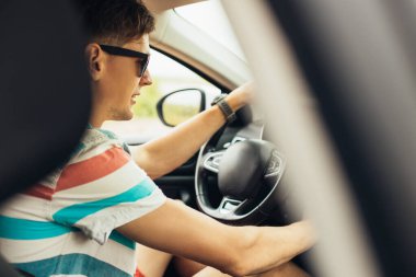 Yola odaklan, genç ve yakışıklı bir adamın araba sürerken dik dik bakışları, bir arabanın sürücü koltuğundaki bir adam.