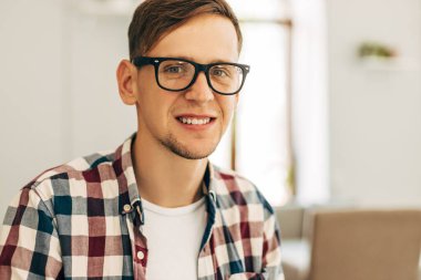 Çekici erkek işçi kafeteryada bilgisayar kullanıyor, genç adam dizüstü bilgisayar kullanıyor.