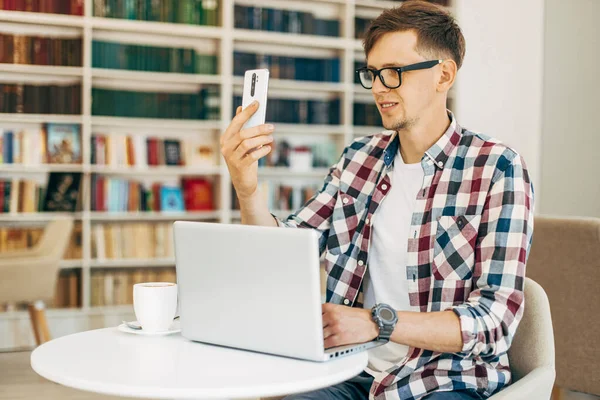 Joven Hombre Feliz Con Gafas Una Camisa Sonríe Mientras Lee — Foto de Stock