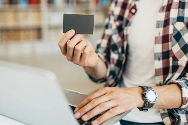 持有信用卡和使用笔记本电脑的男子的特写镜头 网上购物的概念 网上付款 — 图库照片