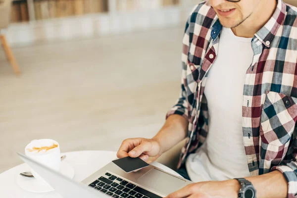 Kredi kartı tutan ve dizüstü bilgisayar kullanan adamın yakın plan fotoğrafları, online alışveriş konsepti, online ödeme