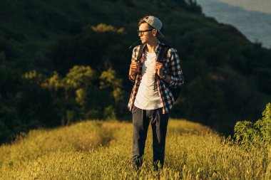 Genç gezgin, gözlüklü, şapkalı, sırt çantalı, doğa ormanlarında yürüyen, doğa yürüyüşü yapan, aktif insanlar.