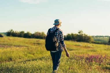 Sırt çantalı genç adam dağ yolunda yürüyor, dağ yolunda yürüyüş yapıyor.