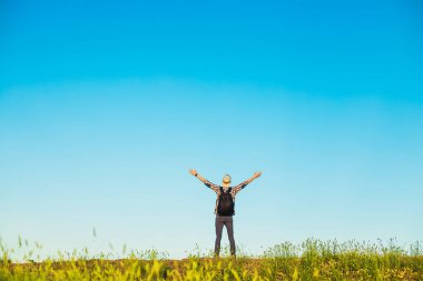 Geniş kolları olan bir adamın arka planında kolları havada mutlu bir adam gün batımının arka planında, doğada, seyahat konseptinde, doğa, özgürlük