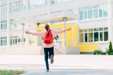 Gözlüklü mutlu çocuk okula gidiyor, çantalı çocuk ilkokula gidiyor, ilkokul çocuğu, öğrenci sırt çantasıyla okula gidiyor, yaz tatilinden sonra okula dönüyor.