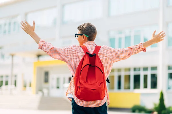 배낭을 채즐거운 마음으로 학교로 달려가는 학교의 배경에 남학생 — 스톡 사진