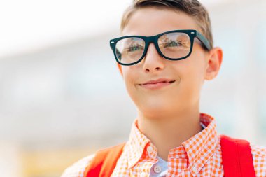 Okul çantasıyla okula giden gözlüklü sevimli bir çocuğun portresi okula giden öğrenci, çocuklar için öğrenim...