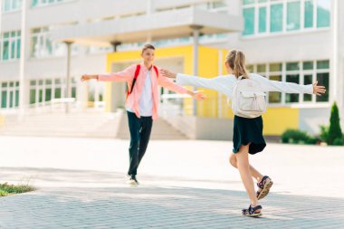 Okula dönelim. Mutlu çocuklar ilkokula hazır, mutlu sınıf arkadaşları karantina ya da yaz tatilinden sonra birbirlerini selamlıyorlar, arka bahçede sırt çantasıyla, sınıfın ilk gününde öğrencilerle, çocuklara öğretmenlik yapıyorlar.