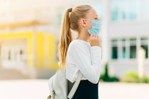 子供のための病気からの保護 コロナウイルスの予防のためのマスク マスクを介して呼吸する女の子は バックパックで学校に行きます — ストック写真