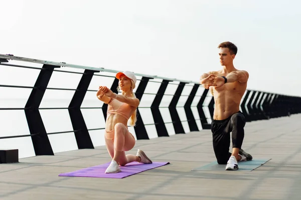 Aantrekkelijk Jong Fitnesspaar Doet Stretching Oefeningen Buiten Zee Brug Sportieve — Stockfoto