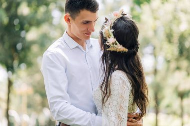 Mutlu gelin ve damat ailesi, yeni evliler gibi gülümsüyor güneşli bir günde parkta aşk ve mutluluk kavramı, düğün günü, boho tarzında düğün töreni.