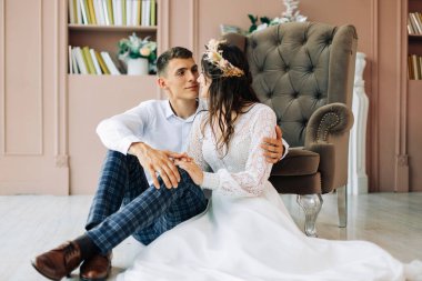 Gelin ve damat stüdyoda fotoğraf çekimi için poz veriyor ve gülümsüyor stüdyoda güzel gelin ve damat, düğün çifti