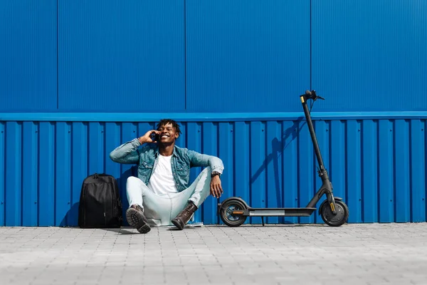 Noir Afro Américain Assis Contre Mur Bleu Avec Scooter Électrique — Photo