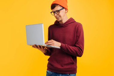 Bilgisayarında daktilo kullanan, gözlüklü turuncu şapkalı, kırmızı kazaklı, sarı arka planda, yüksek hızlı internetli, 5 gr.