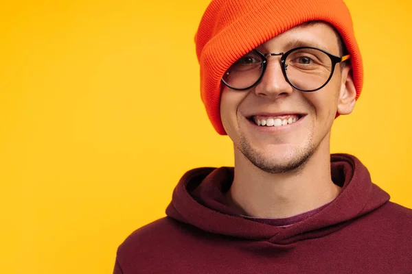 オレンジの帽子と眼鏡の幸せな男の肖像画 黄色の背景 冬や秋の帽子 寒い天候で コンセプト 冬や春のための温暖化 暖かい服 — ストック写真