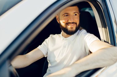 Yeni bir araba alan erkek sürücü, bir otomobil bayiinde yeni bir araba seçerken test sürüşü yapar