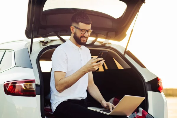 Jovem Sorrindo Homem Com Barba Usa Smartphone Sentado Carro Com — Fotografia de Stock