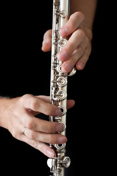 Flute in the musician\'s hands on a black background