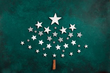 Yeşil arka planda beyaz ahşap yıldızlardan yapılmış orijinal Noel ağacı. Üst manzara, yakın plan. Noel, Yeni Yıl konsepti.