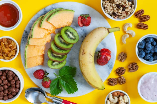 健康的な朝食シャルキュトリボード グラノーラ ヨーグルト 果物や果実の品種 ナッツやフレーク明るい夏の背景に — ストック写真