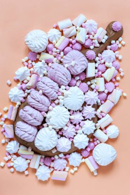 Meringue and variety Marshmallows charcuterie board on pink background. Close up, top view.	