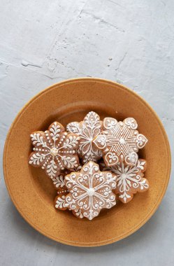  Ev yapımı kar tanesi şeklinde zencefilli kek. Üst manzara, yakın plan, açık gri beton arka plan.
