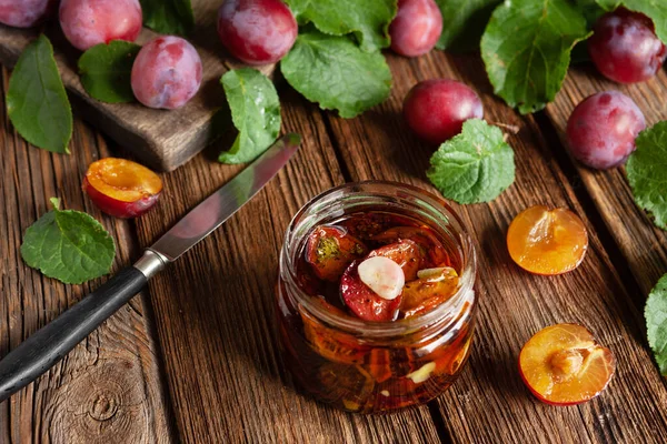 Plum Kering Dalam Botol Kaca Dengan Minyak Zaitun Dengan Bawang Stok Foto Bebas Royalti