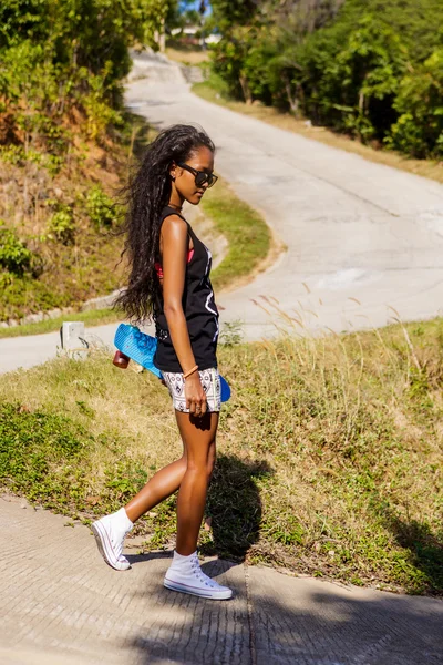 Retrato al aire libre de una adolescente negra con longboard azul ska — Foto de Stock