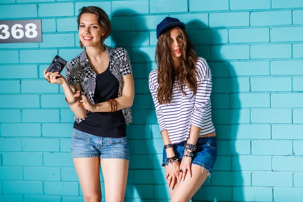 Jóvenes felices con cámara de fotos divirtiéndose delante de azul —  Fotos de Stock