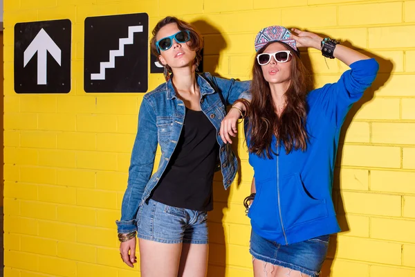Glückliche junge Leute haben Spaß vor gelber Backsteinmauer — Stockfoto